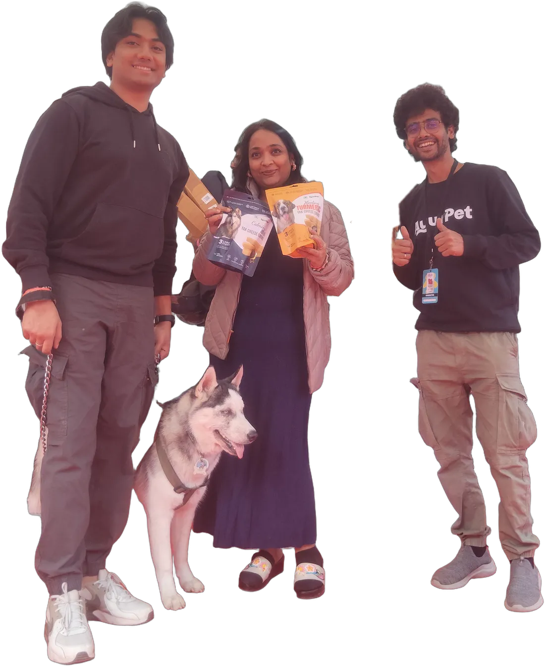 Three TrueSource Global and IndoFolk Wellness team members with a husky, holding pet product samples at a pet industry expo in India