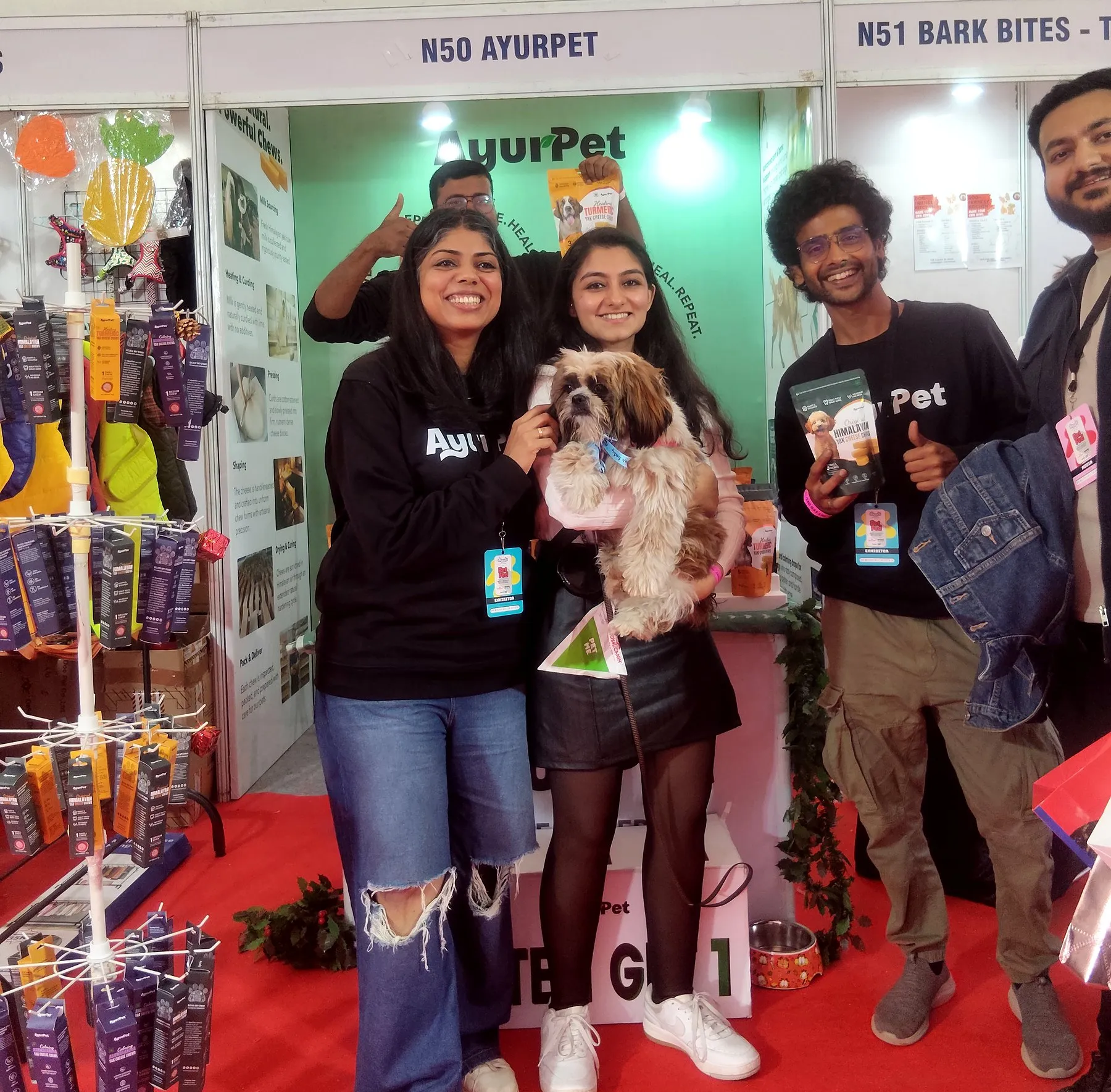TrueSource Global team members holding a Shih Tzu at a pet industry expo in India