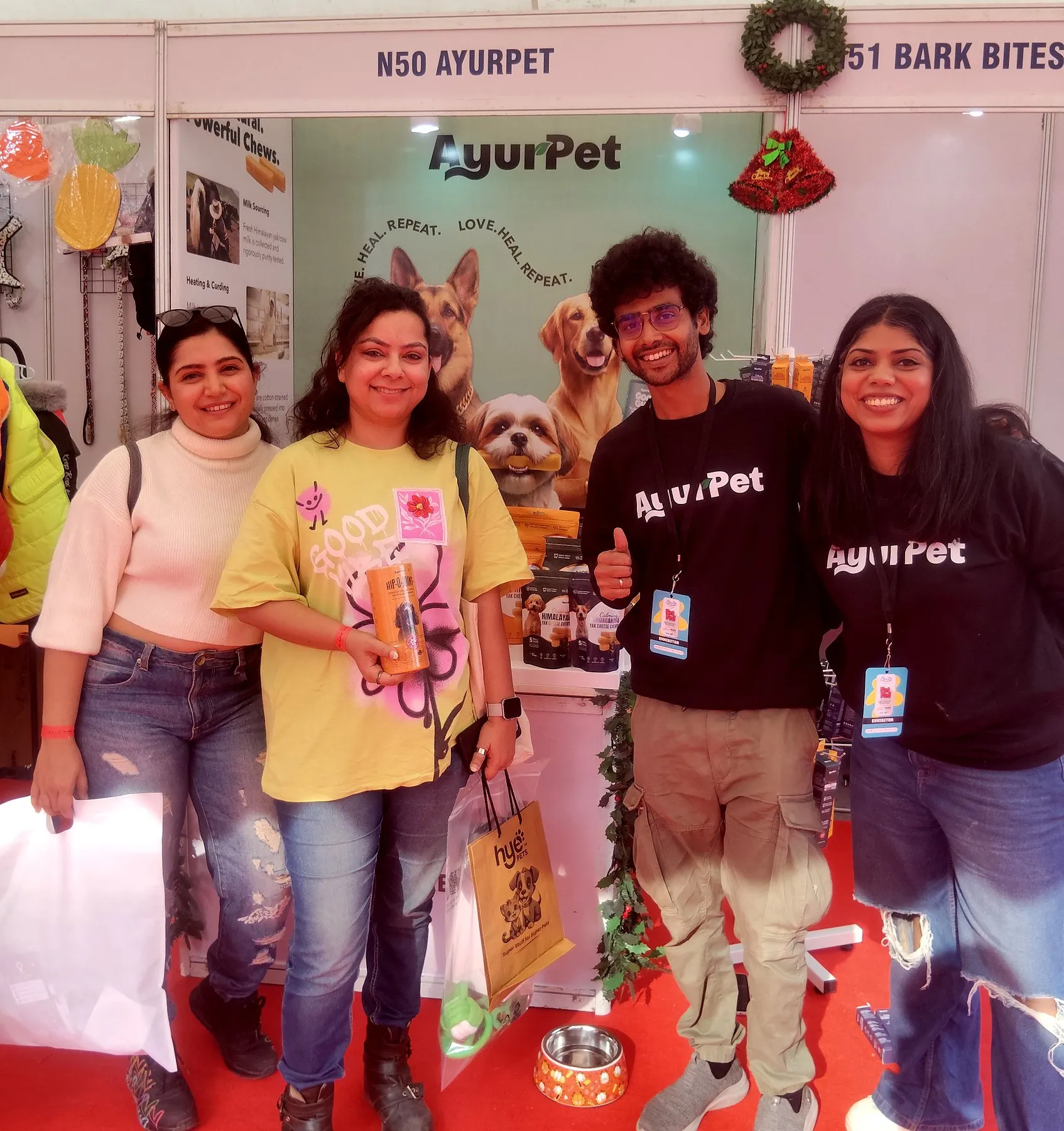 Team members and visitors smiling together at a pet expo stand in India