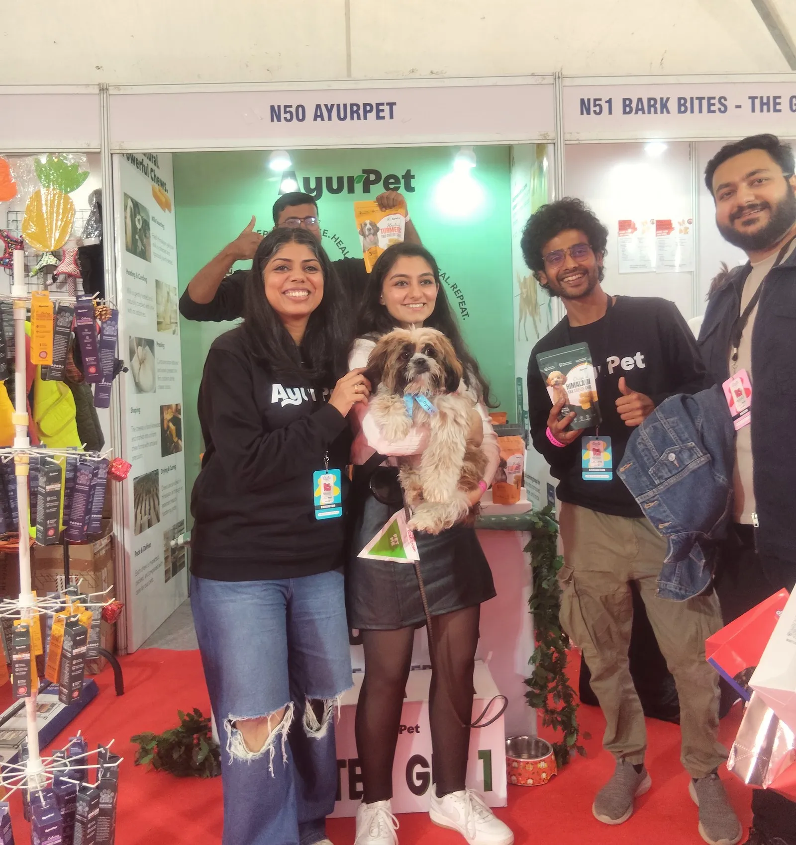 The team with a dog at a pet industry expo in India